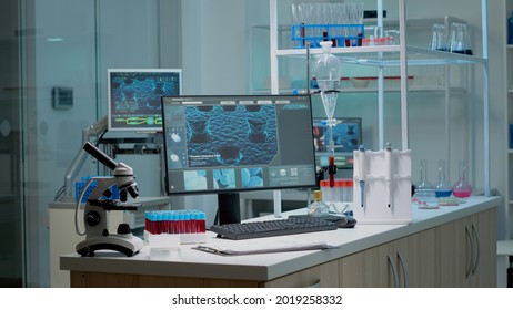Empty laboratory space with biochemistry equipment used for research industry. Scientific room with nobody at chemistry workplace desk. Microscope, pipette and test tubes on table