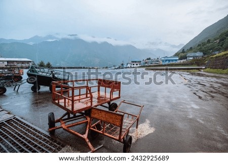 Empty Laggage Carts on the empty runway in Tenzing-Hillary Airport poured with cold rain during non-flying weather day when all flights was cancelled in Lukla village in Himalaya mountains, Nepal. Stock photo © 