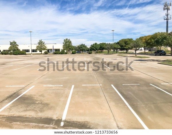 Empty large office parking lots at\
business park in America. Cloud blue sky\
background.