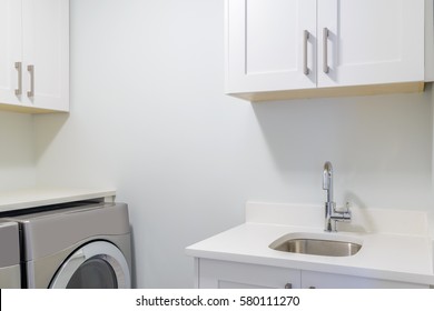 An Empty Laundry Room With Cabinet, Sink, Washer And Drier.