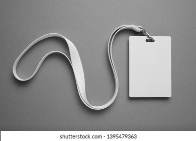 Empty layout layout on grey background. Common blank label name tag hanging on neck with thread.
