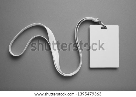 Empty layout layout on grey background. Common blank label name tag hanging on neck with thread.