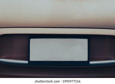 Empty License plate on the back of a beige car