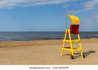 Empty lifeguard chair on the sea beach. Lifeguard equipment to support the observation of people playing in the water. Photo taken at noon on a sunny day