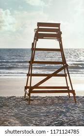 Empty lifeguard stand facing the ocean with small waves and blue skies