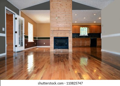 An empty living area with a fireplace.  Behind it is the dining and kitchen area. - Shutterstock ID 110825747