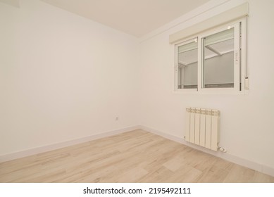 Empty Living Room With Light Wooden Floorboards, White Radiator On The Wall And Sliding Sash Window