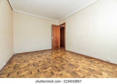 Empty Living Room With Ugly Brown Sunscreen Floor, Dark Wood Door And Plaster Molding On The Ceiling