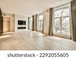 an empty living room with wood flooring and large windows looking out onto the trees that line the street outside