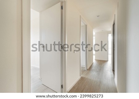 Empty long corridor with open doors to different rooms