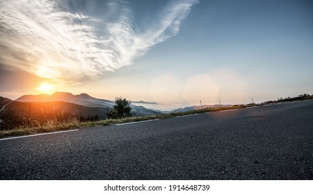 Empty long mountain road to the horizon on a sunny summer day at bright sunset - Shutterstock ID 1914648739