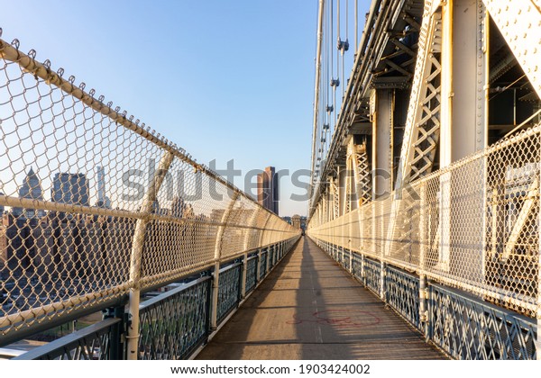 Empty Manhattan Bridge Walkway in New York\
City. Suspension bridge that connects Manhattan with Brooklyn with\
walking path, subway tracks and car\
roads
