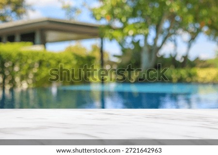 Empty marble table top with blur outdoor swimming pool in tropical resort hotel summer background