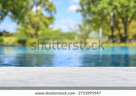 Empty marble table top with blur outdoor swimming pool in tropical resort hotel summer background