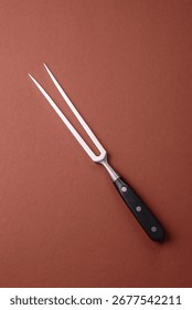Empty meat or steak fork with vegetables, spices and other ingredients. Meat fork as a background for your design