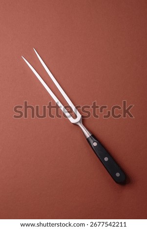 Empty meat or steak fork with vegetables, spices and other ingredients. Meat fork as a background for your design