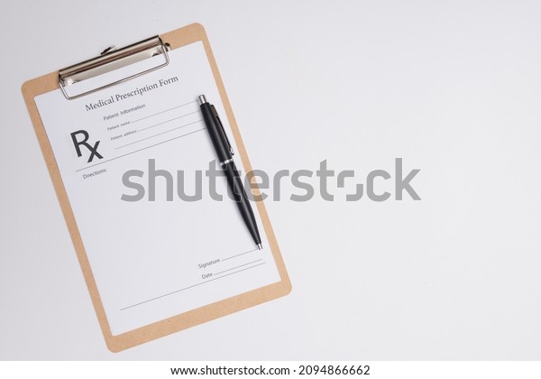 Empty medical prescription with a pen isolated.\
Ballpoint pen lying on medical prescription near phonendoscope in\
doctors office.
