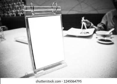 Empty menu frame on table in Japanese Restaurant, People background
