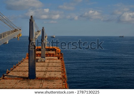 Empty Merchant ship designed to carry container is at anchor near container port
