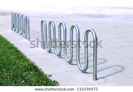 empty metal bike rack in parking lot of campus
