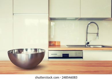 Empty Metal Bowl On Wooden Table And Modern Kitchen Space. Toned In Warm Colors