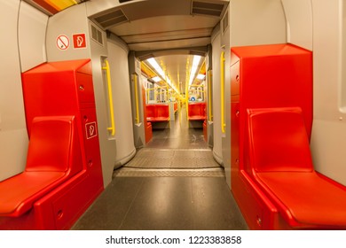 Empty metro train interior with red seats, city transport