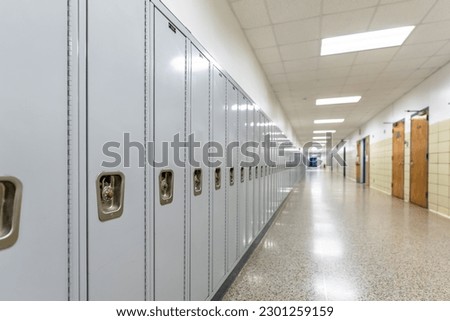 Empty middle school or high school hallway with gray student lockers

