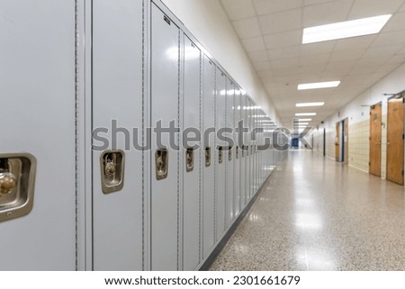 Empty middle school or high school hallway with gray student lockers
