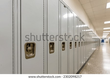Empty middle school or high school hallway with gray student lockers
