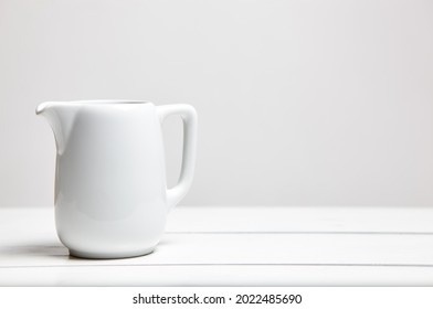 Empty Milk Jug On Wooden Background. Porcelain Sauce Boat, Pitcher, Creamer Or Ceramic Gravy Boat