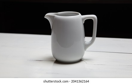 Empty Milk Jug On Wooden Background. Porcelain Sauce Boat, Pitcher, Creamer Or Ceramic Gravy Boat