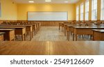 Empty modern classroom with chairs, desks and chalkboard.