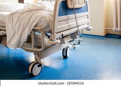 Empty modern hospital bed in a sunny room with a clean blue floor