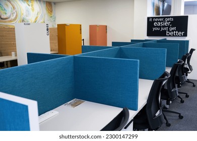 Empty modern office space with row of desks separated by desk dividers