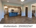 Empty modern townhouse floor showcasing a kitchen with living and dinning room ready to be moved in. Investment, renting, or house ownership concept.