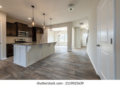 Empty modern townhouse floor showcasing a kitchen with living and dinning room ready to be moved in. Real estate, investment, renting, or house ownership concept.