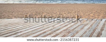 An empty modern wooden promenade through the sandy shore of the Baltic sea. Sport, recreation, cycling, nordic walking, relaxation, vacations, weekend, tourism, leisure activity concept