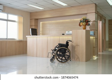 Empty Modern Wooden Reception Counter With Monitor And Wheelchair Service In The Hospital