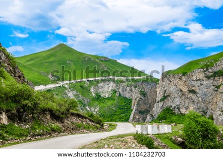 Empty mountain road in the High Caucasus mountain, Azerbaijan - spring shot in clear weather with green hills
