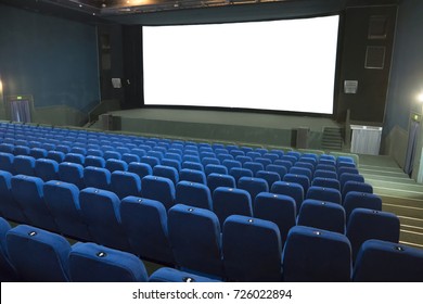 Empty movie cinema with rows of blue seats and white isolated screen