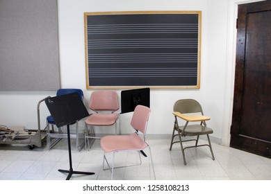 An Empty Music Classroom With Scattered Chairs