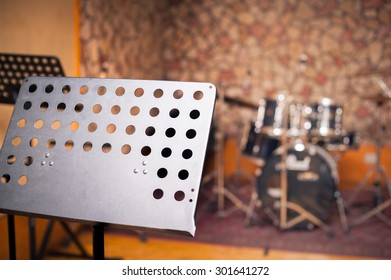 Empty Music Stand In Studio With Out Of Focus Drums In Background