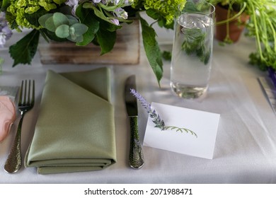 Empty Name Card With A Sprig Of Lavender Along With A Green And White Themed Table Setting Of A Bridal Shower Brunch.