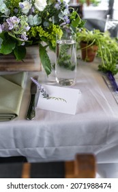 Empty Name Card With A Sprig Of Lavender Along With A Green And White Themed Table Setting Of A Bridal Shower Brunch.