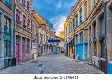 Empty narrow cobblestone street, paving stone road, old colorful buildings with brick walls in Lille historical city centre, French Flanders, Nord department, Hauts-de-France Region, Northern France - Powered by Shutterstock