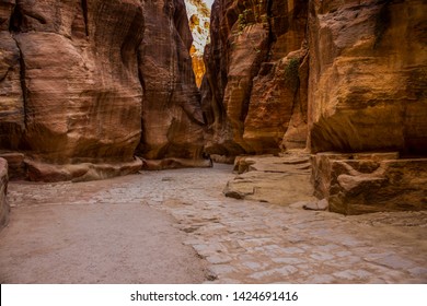 empty narrow path way between steep sand stone rocks inside canyon dry scenic wilderness nature environment 