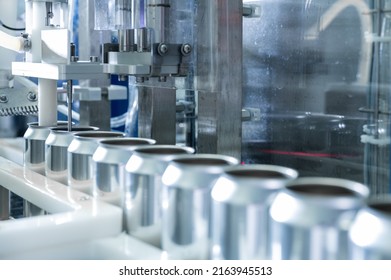 Empty New Aluminum Cans For Drink Process In Factory Line On Conveyor Belt Machine At Beverage Manufacturing. Food And Beverage Industrial Business Concept. High Quality Photo