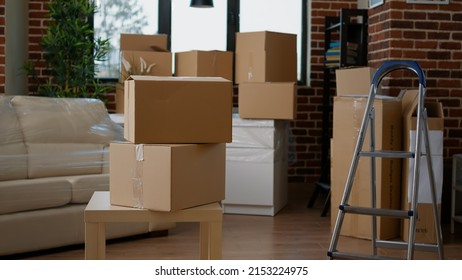 Empty New Apartment Space With Furniture Packages In Boxes, Moving In Household Property. No People In Real Estate House To Move With Things In Storage Cardboard Cargo Containers.