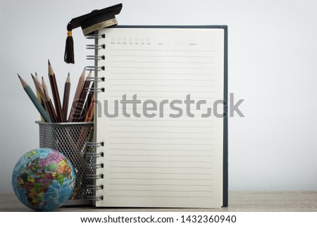 Empty notebook mockup for your image text with pencils, world globe, graduation hat on white background. Concept of global business study abroad educational. Back to School.