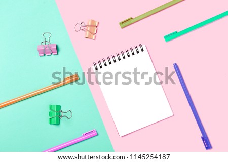 Empty Notebook or notepad on pink and blue background. Creative minimalism chancery concept. Top view, flat lay.